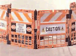 [Image Description: An orange barrier blocking a manhole in the street.]