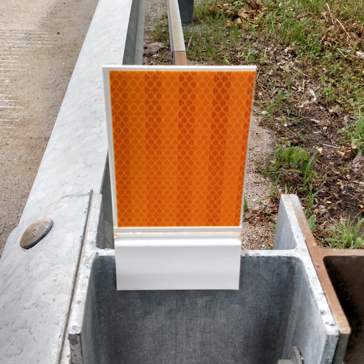 [Image Description: A Flex-O-Matic Delineator mounted on top of a guardrail.]